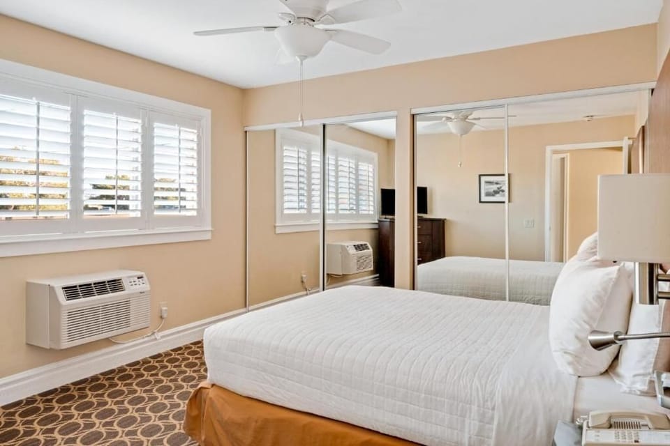 Unwind in crisp linens beside bright shutters and calm tones.