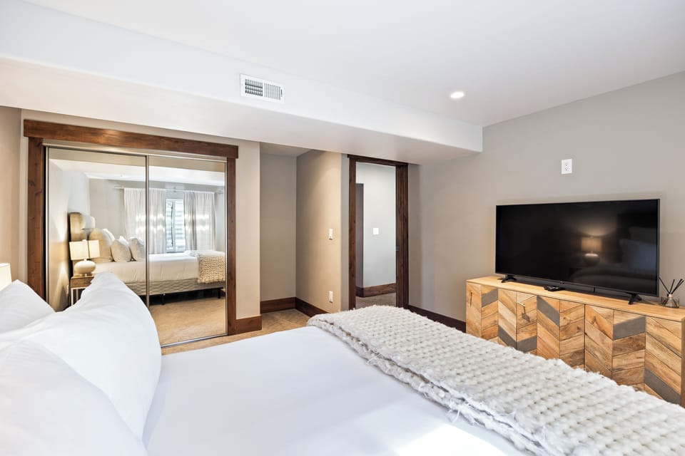 Comfortable basement guest bedroom with cozy bedding, modern furnishings, and a peaceful atmosphere for restful stays.