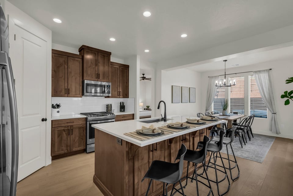 A chef-ready kitchen with stainless steel appliances, solid-surface countertops, a large island with bar seating, and all the cookware you need to feel right at home.