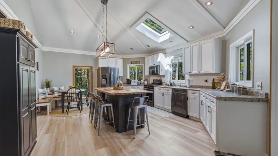 The big kitchen island with bar stools creates the perfect spot for casual breakfasts, coffee chats, or helping hands while cooking.