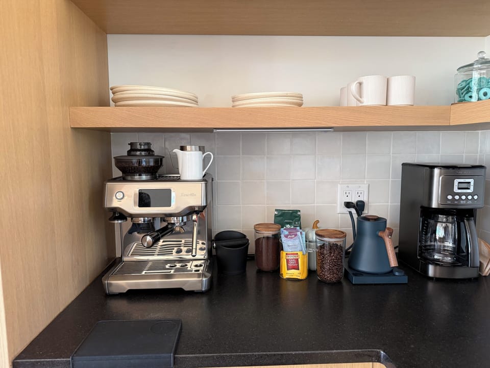 Modern coffee station with espresso machine, drip brewer, and essentials