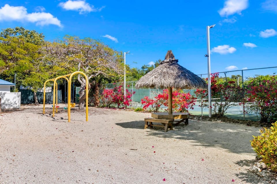 Let the kids swing and play while you enjoy the shade of the thatched hut nearby.