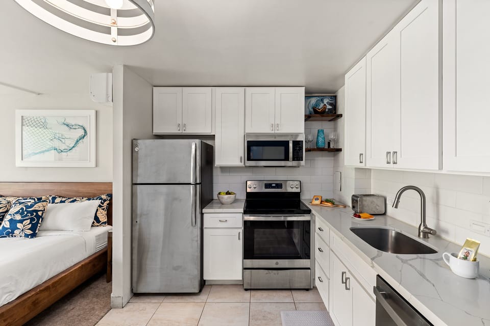 Fully equipped kitchen with stainless steel appliances and white cabinetry