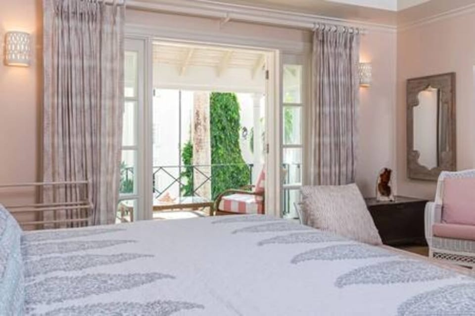 Spacious en suite bedroom with US king size bed, air conditioning, ceiling fan and a private balcony.