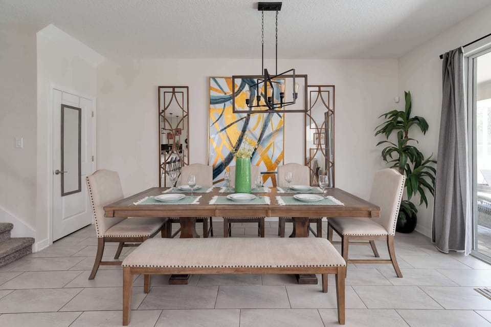 Modern dining area with a wooden table, upholstered chairs, and abstract wall art.
