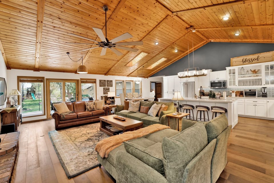 Cozy mountain living room with a stone fireplace, comfy seating, and smart TV—perfect for relaxing evenings, movie nights, and warm cabin vibes after outdoor adventures.
