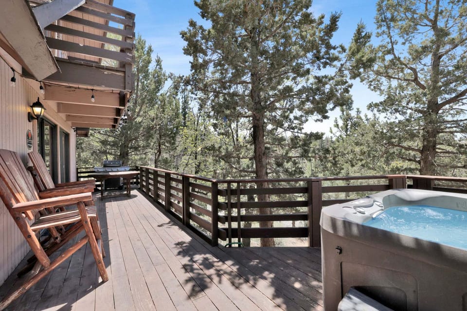 Private outdoor deck with a BBQ, surrounded by tall pines, perfect for relaxing under the trees after a day of adventure—enjoy peaceful forest views,
