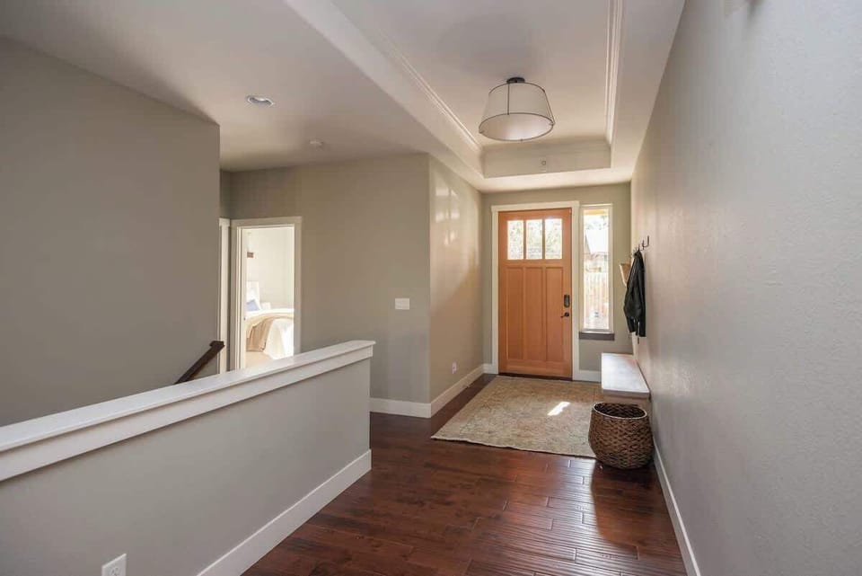 Eantrance and East Wing. Stairwell to lower level and hallway to Guest Bedrooms and Baths.