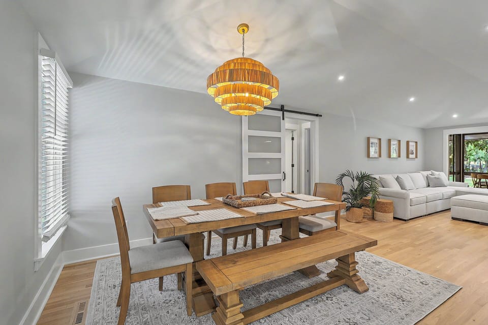 A wider view from the dining table emphasizes the relaxed boho ambiance, showcasing how the space flows naturally into the bright main living room lounge.