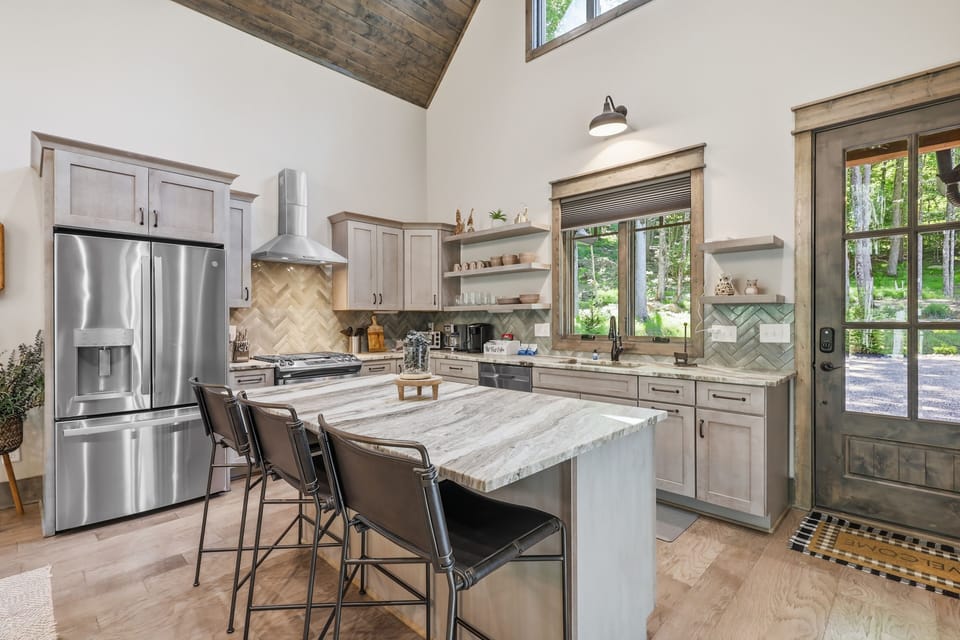 Designer kitchen featuring forest views and spacious island seating — a bright, stylish space perfect for cooking, gathering, and enjoying meals with a stunning natural backdrop.