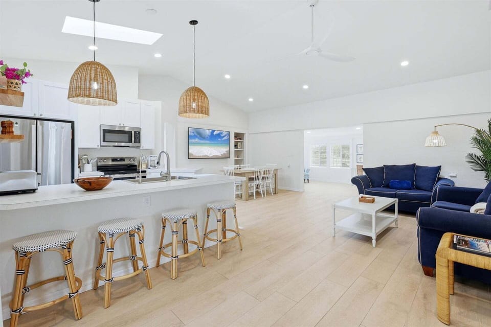 Bright, open living space with comfy seating, 75-inch Smart TV, and lanai access