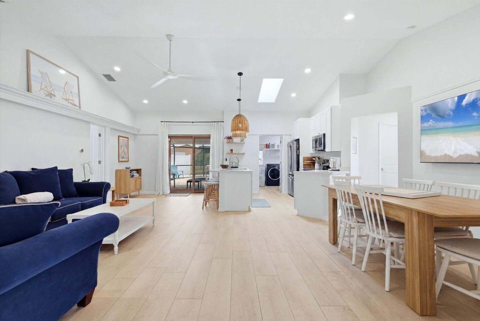 Bright, open living space with comfy seating, 75-inch Smart TV, and lanai access