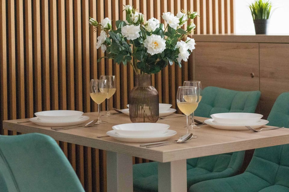 A dining table set with decorative flowers and tableware. The arrangement feels elegant and welcoming