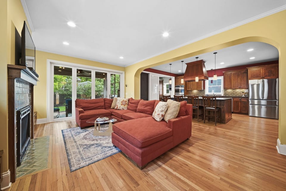 Sink into plush seating and enjoy seamless flow from your living space to a gourmet kitchen, where warm wood tones and backyard views invite relaxation.