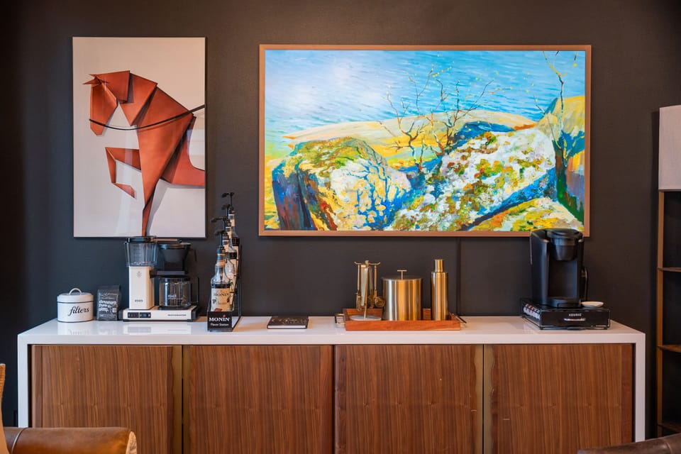 Fully stocked coffee & tea bar with syrups, mugs, and brew options and Frame TV