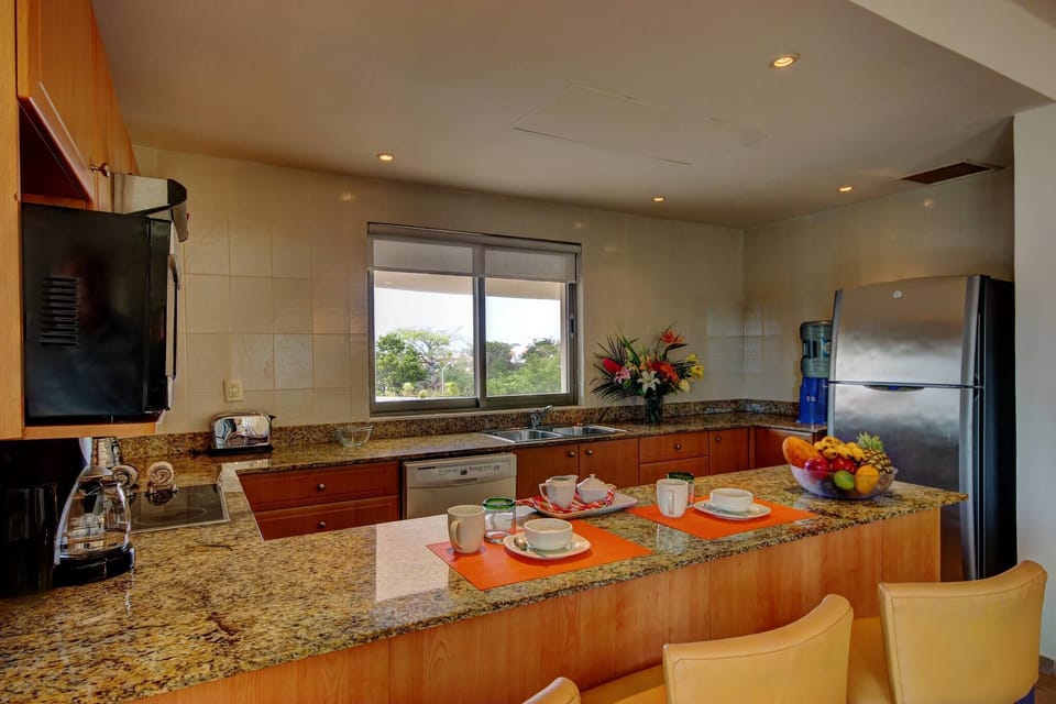 Kitchen with quality utensils and a dishwasher. Large refrigerator and electric stove.