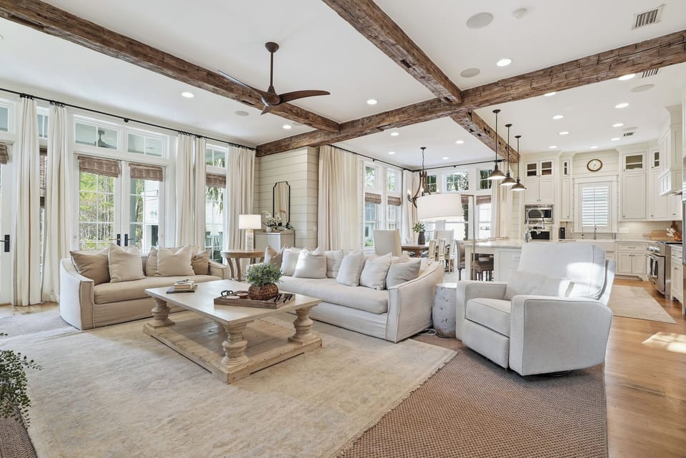Relax in this spacious open-concept living area where rustic beams meet modern elegance. Sunlight streams through large windows, creating a warm, inviting atmosphere perfect for your getaway.