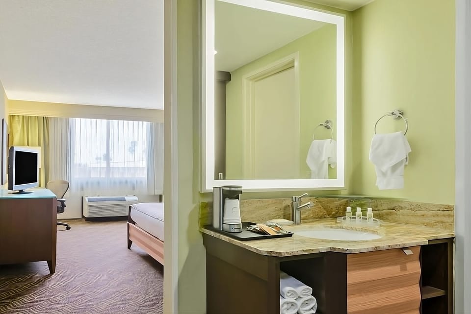 Wake up gently with sunny room views beyond the vanity.