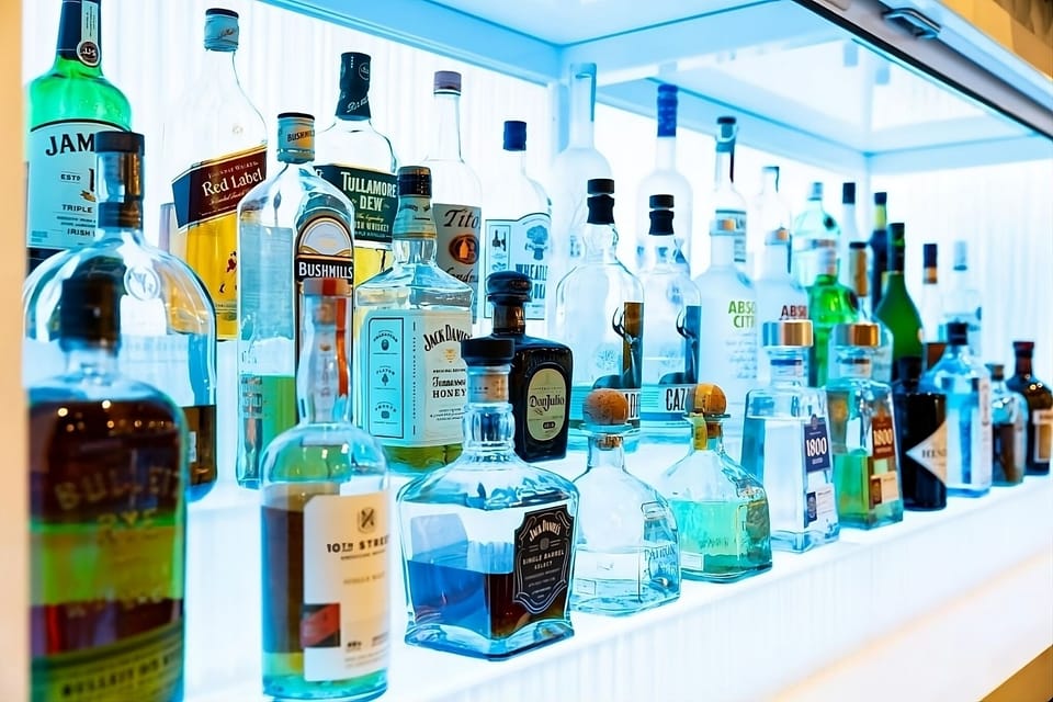 Toast the evening with curated spirits glowing behind the bar.
