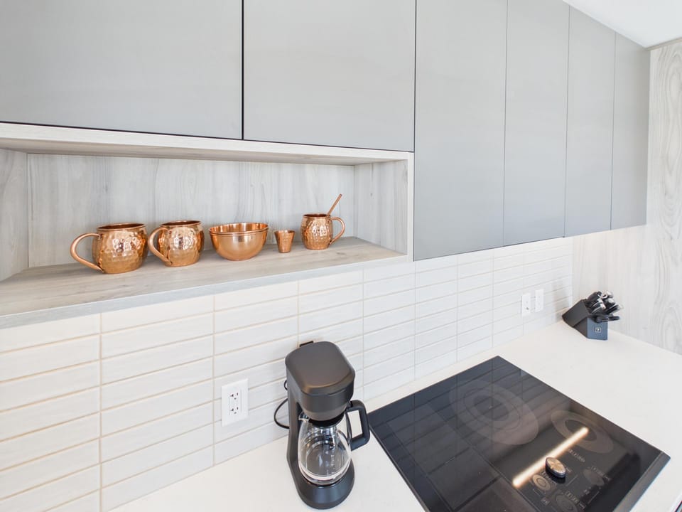 Start your mornings right with a dedicated coffee bar station set against a classic, modern white subway tile backsplash.