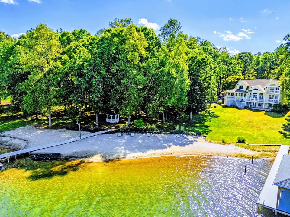 From Above - The full estate from a bird's eye: lakefront frontage, multiple decks, mature grounds.