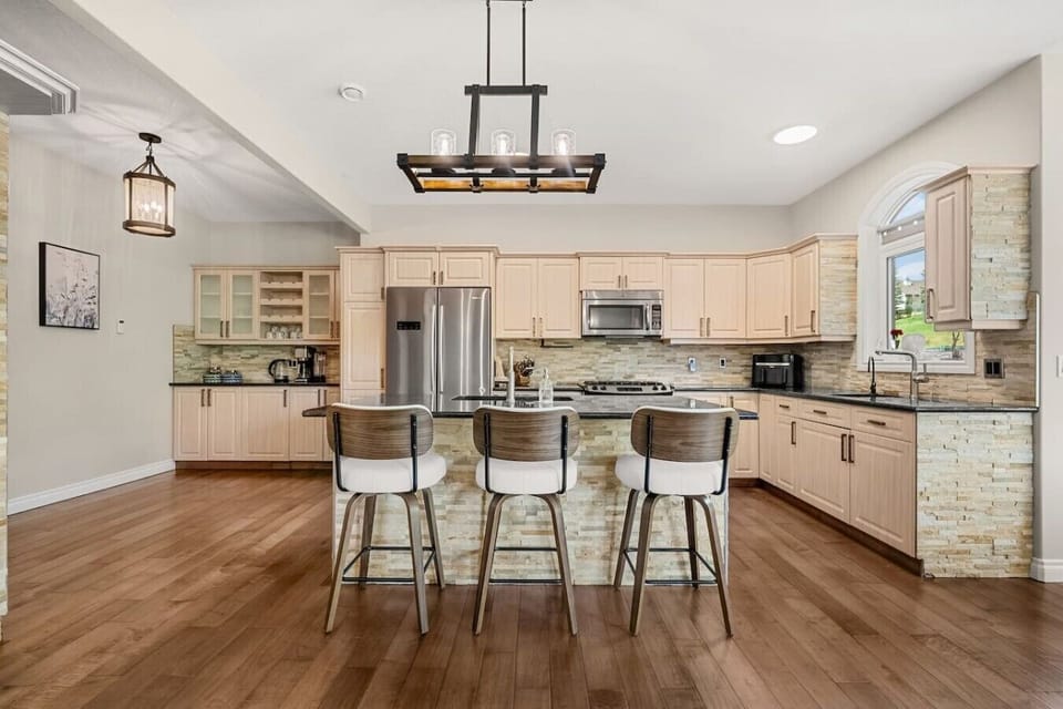 Expansive, full kitchen with a selection of coffee makers (drip, Keurig & french press), blender, crockpot/slow cooker, food processor, air fryer, reverse osmosis water tap and a gas stove. The kitchen is stocked with ground coffee, tea, sugar and basic c