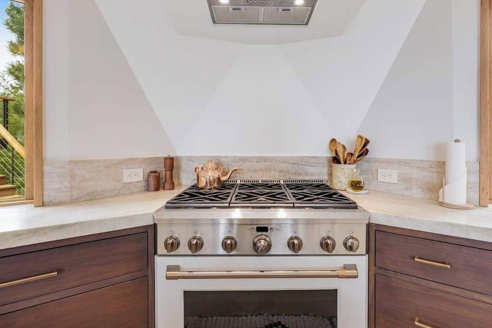 Create culinary masterpieces in this stylish kitchen, where modern appliances and a serene view elevate your cooking experience.