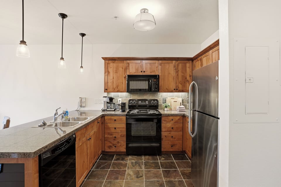 Cozy full kitchen with stainless appliances and rustic wood cabinets