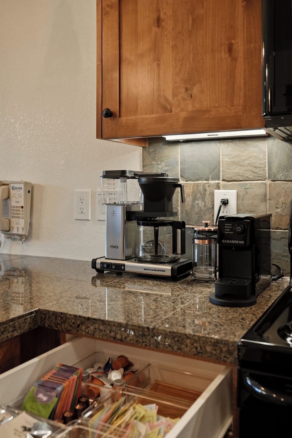Fully stocked coffee station with granite counters and dual brew options