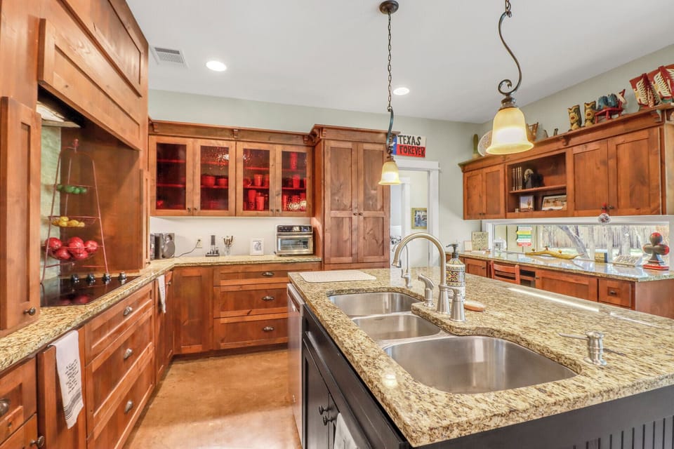 Your gourmet kitchen invites culinary adventures with granite counters, double sinks, and warm wood cabinets creating the perfect cooking sanctuary.
