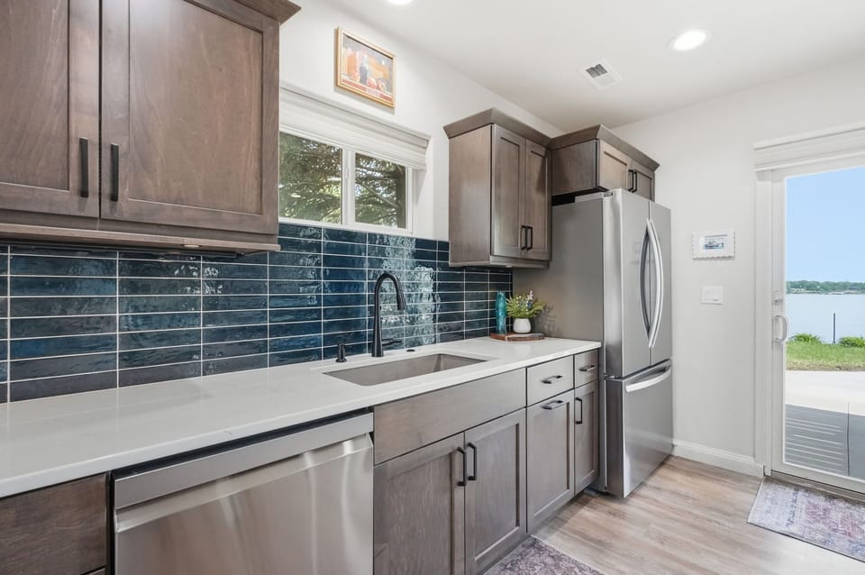 Full kitchen on main level with stainless steel appliances, quartz countertops and tile backsplash & granite composite sink.