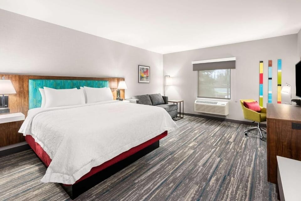 Unwind on plush bedding with cozy lounge seating nearby.