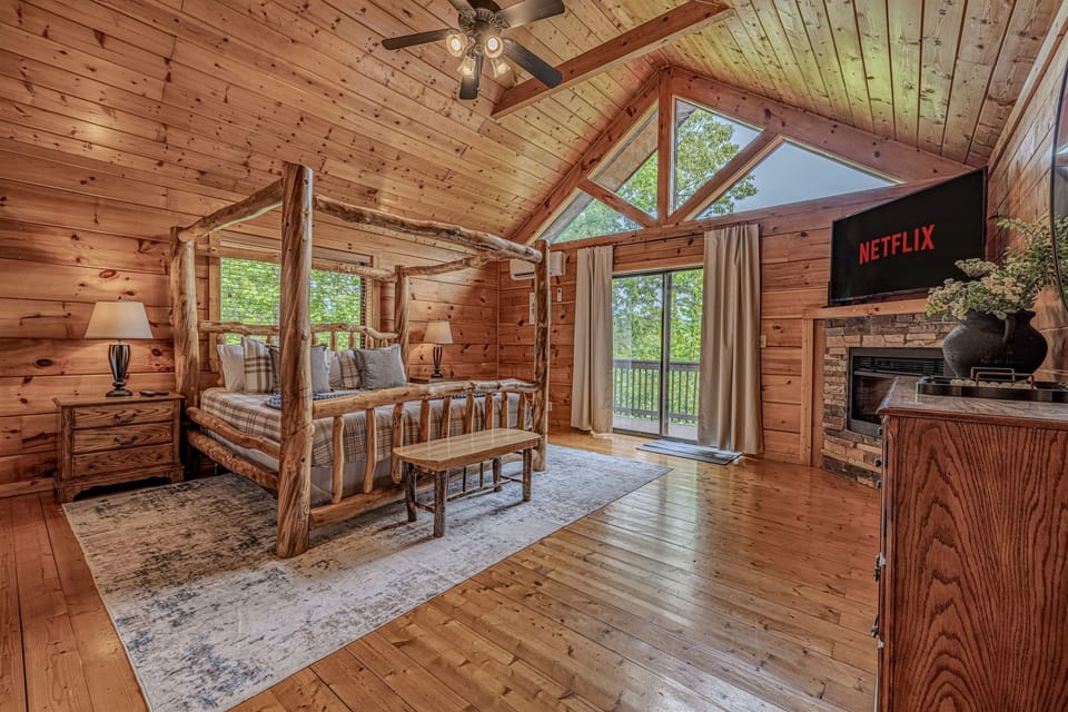 The master bedroom features a private TV, allowing guests to wind down in bed with their favorite shows after a day of exploring the Smoky Mountains.