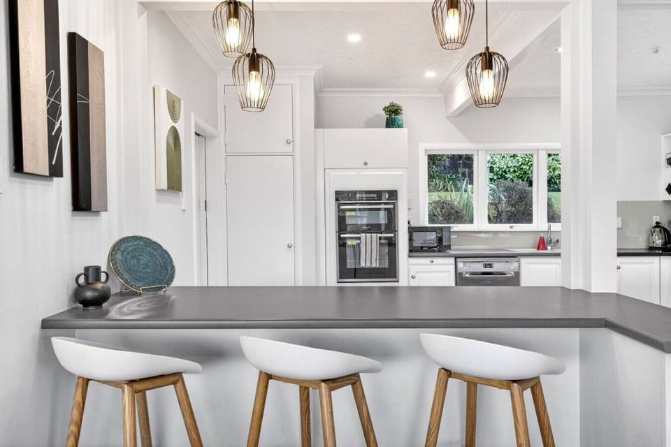 Gather around your sleek island with pendant lighting overhead while you prep meals in this chef`s kitchen with dual ovens and garden views.