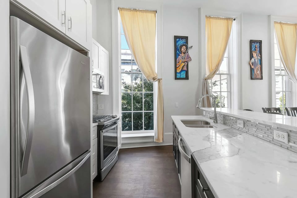 Fully equipped kitchen with a granite island, stainless appliances, full cookware, coffee maker and dining seating. Bright, modern layout ideal for quick meals or cooking for guests—easy, convenient New Orleans base