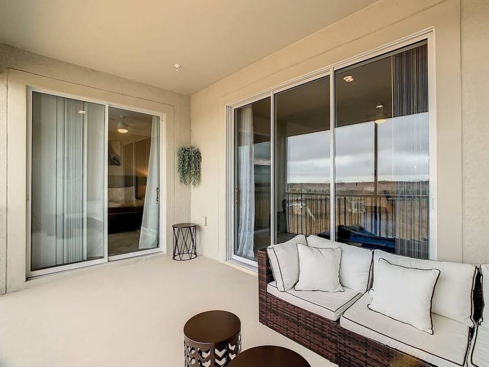 Spacious screened balcony with cozy wicker lounge seating