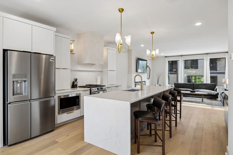Kitchen: A spacious kitchen featuring a large island, bar stools, and pendant lights above.