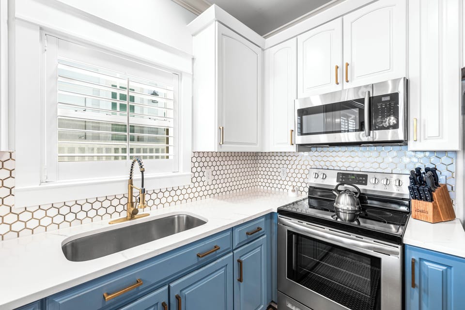 Deep stainless-stee sink with touch faucet and modern appliances.