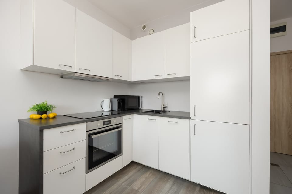 A compact kitchen area with cabinetry and a clean countertop layout. Everything is neatly arranged, emphasizing practicality and style.