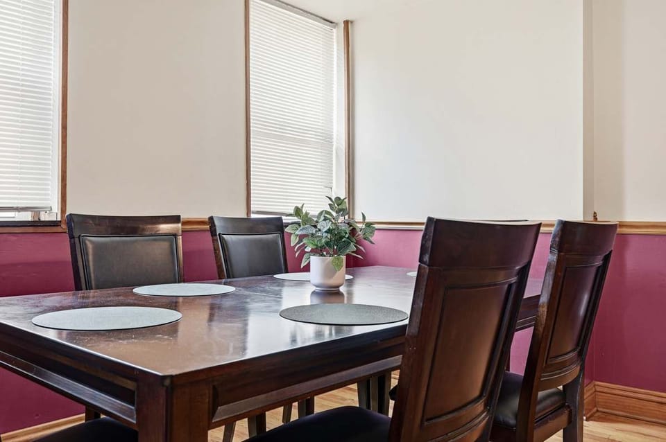 Elegant dark wood dining table w/ chairs, dressed w/ a fresh floral touch.
