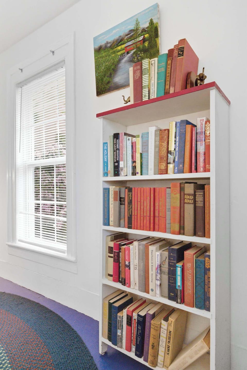 A curated bookshelf and reading nook add warmth and character to the space.
