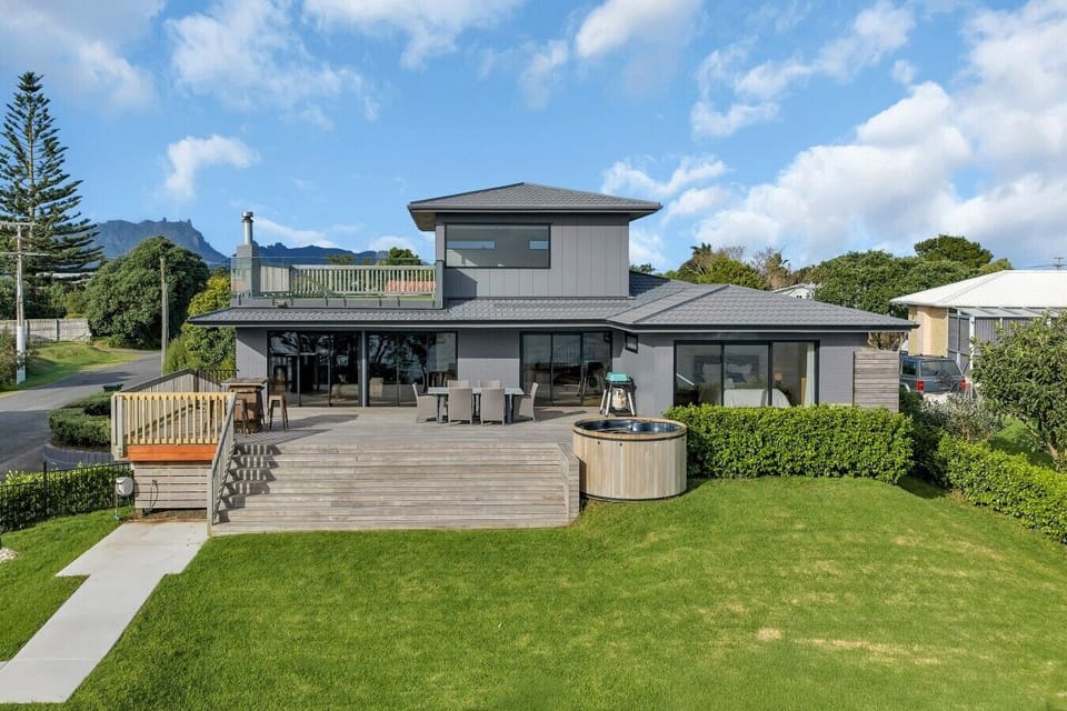 Large deck equipped with a BBQ, outdoor dining table, and a private hot tub. The ultimate setup for relaxing and entertaining while taking in the views.