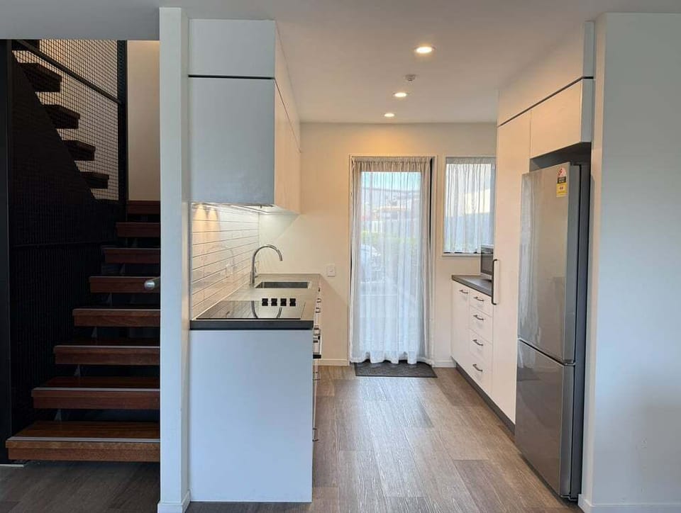 Set up for cooking a proper meal — Bosch oven, induction hob, dishwasher, full-size fridge, generous bench space.