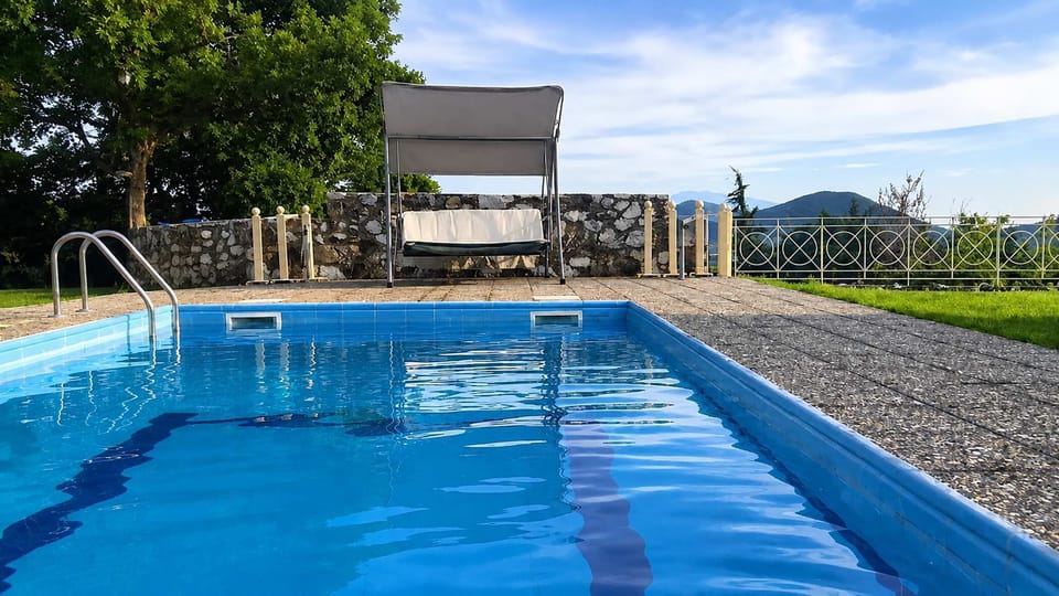 The shared pool opens toward the surrounding hills and gardens, creating a peaceful setting for long afternoons under the mountain sun.