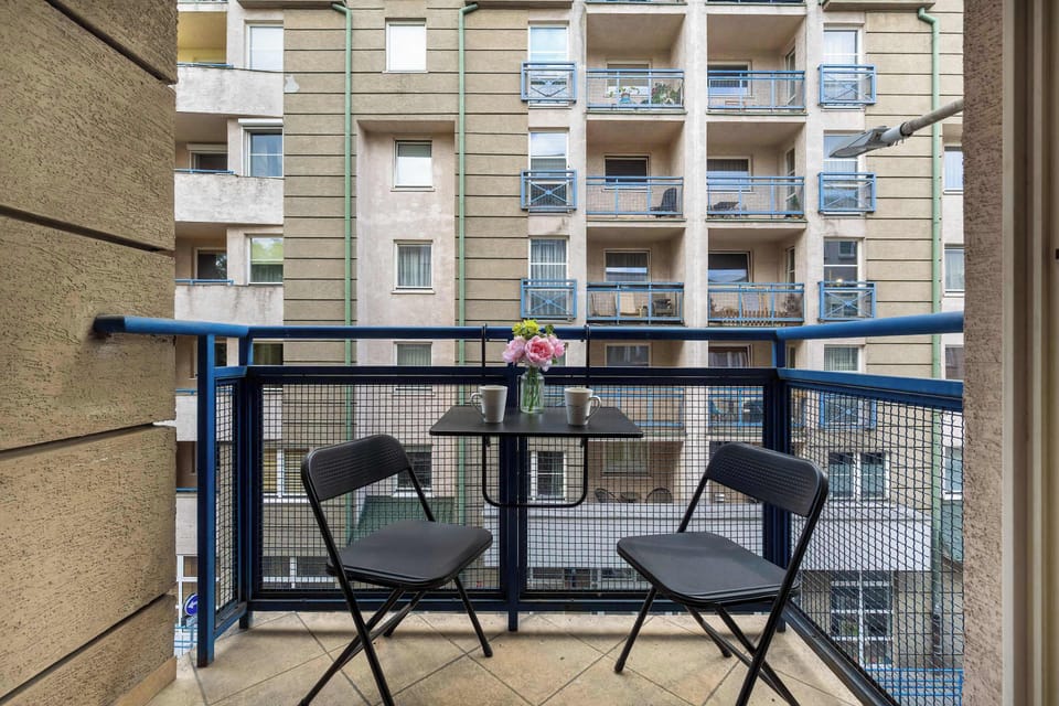 Cozy balcony with table and chairs in modern residential complex