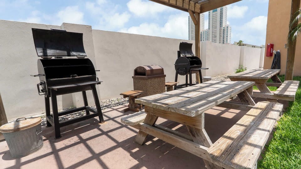 A relaxed outdoor gathering spot with shaded seating and a clean, open layout that feels easy and welcoming. Warm wood tones and simple touches create a comfortable place for guests to unwind, share meals, and enjoy time together.