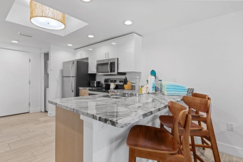 Cook and dine with ease in a sleek kitchen featuring modern stainless steel appliances and a spacious breakfast bar.
