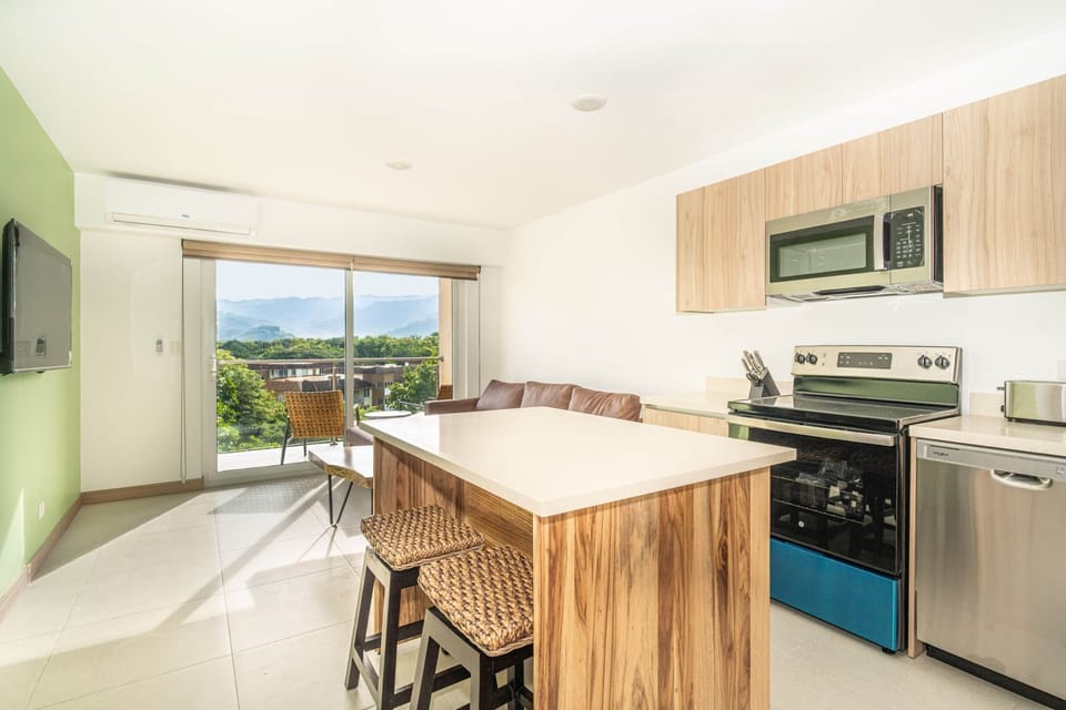 microwave, kitchen visible, indoor, kitchen, climate control, oven, television, stovetop, dining table, unit views