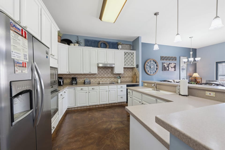 Your spacious kitchen features gleaming white cabinetry, modern stainless appliances, and ample counter space perfect for whipping up vacation meals together with family and friends.