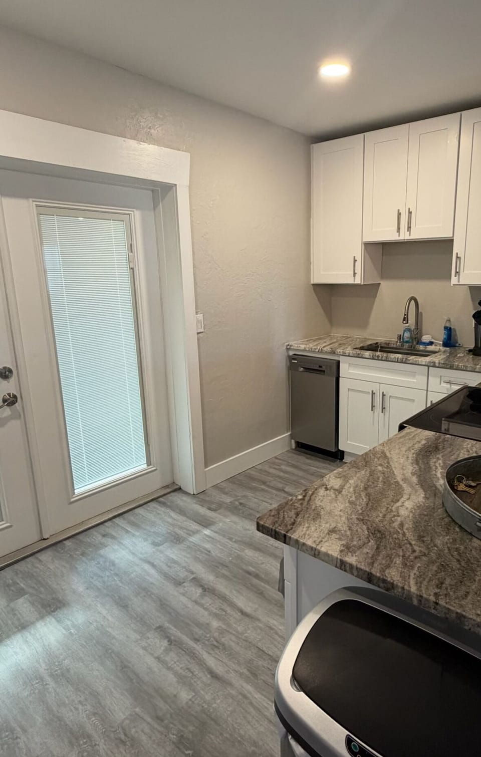 Kitchen with door to enclosed back patio which has washer and dryer for use.